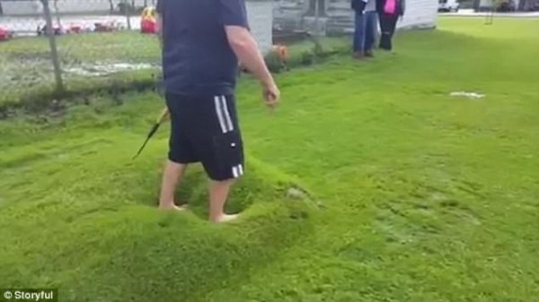 „Nie próbujcie tego w domu, dzieciaki”: Mężczyzna, który po ulewnym deszczu znalazł „bąbel wody” pod trawnikiem, wskoczył na niego, a następnie UDERZŁ go kijem
